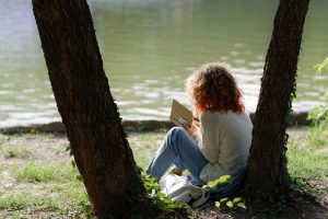 photo of woman reading beneath a tree